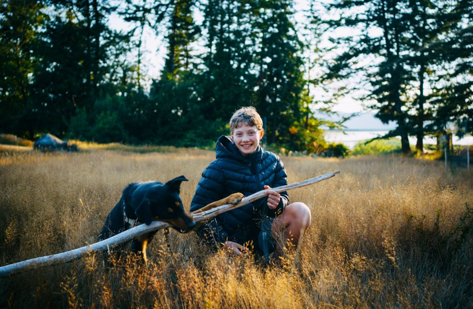 Gwen playing with her dog in a golden field